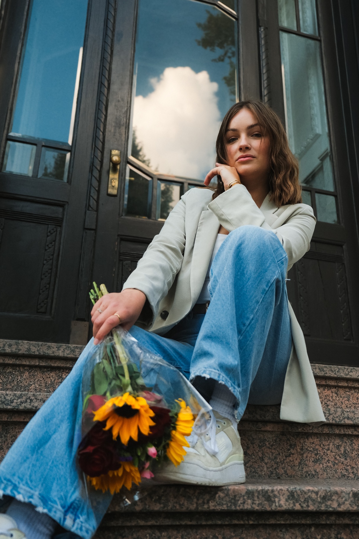 Frau mit Blumenstrauß auf Treppe